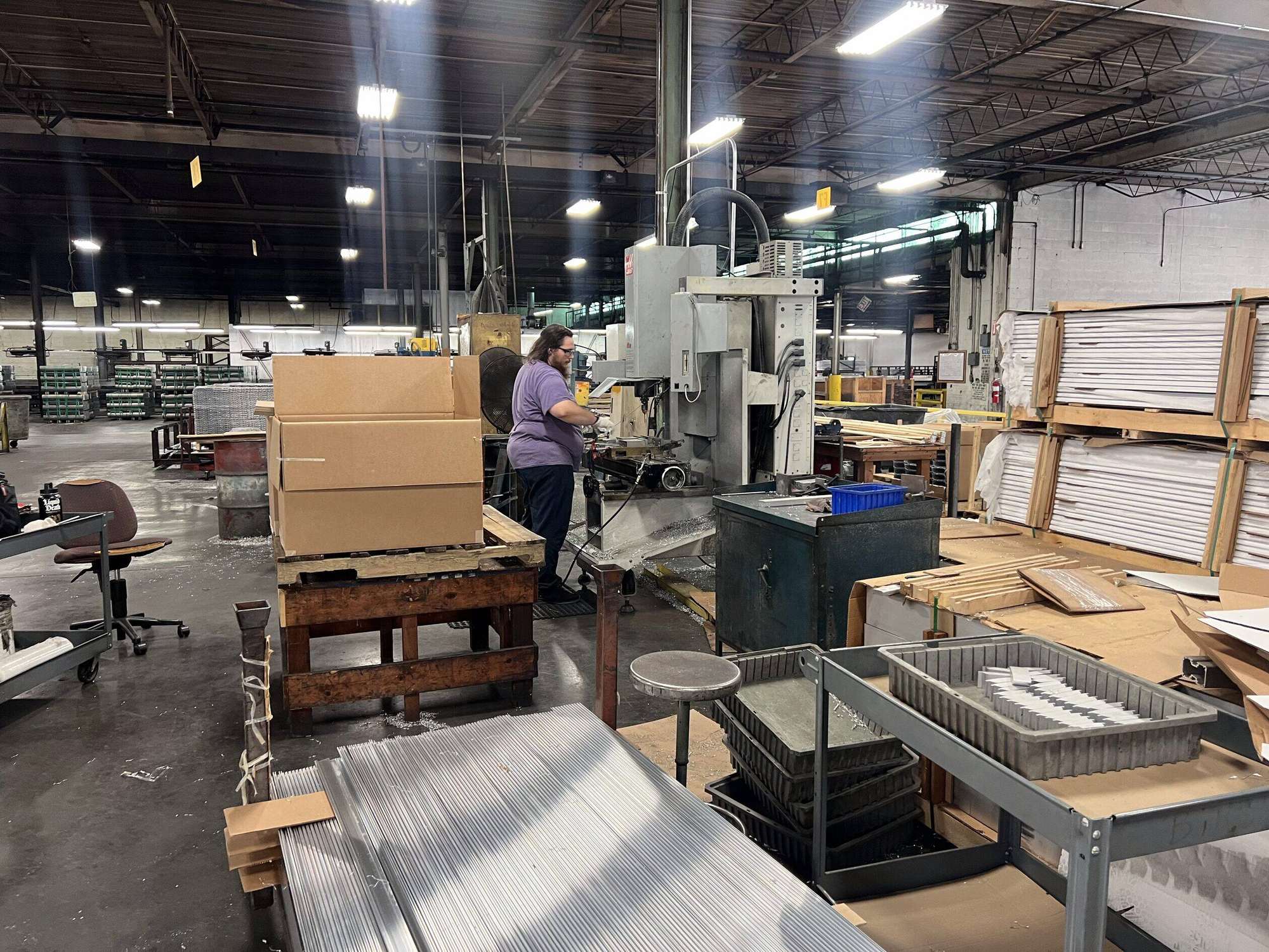 Fabrication bench with cut aluminum stock and formed parts at AES
