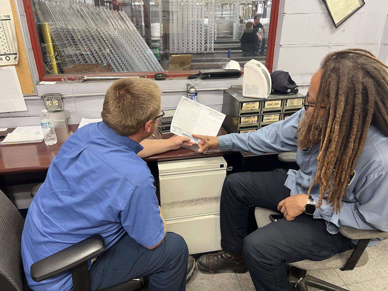 Two AES team members reviewing a customer drawing together on the Cincinnati floor